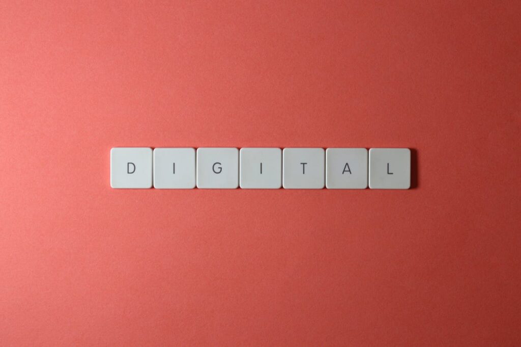 Close-up of keyboard tiles spelling 'DIGITAL' on a red background, perfect for tech themes.