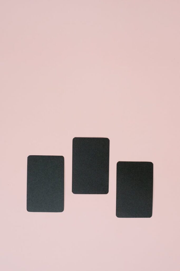 Three black rectangular cards arranged vertically on a pink background, ideal for mockup or design.